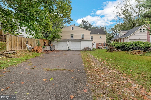 back of property with a garage and a lawn