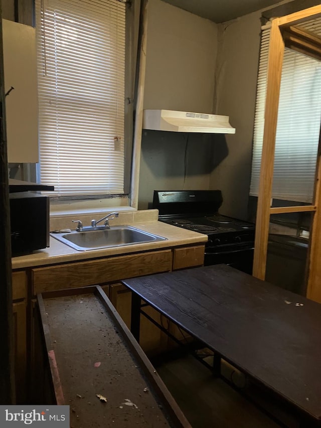 kitchen with ventilation hood, black gas stove, and sink