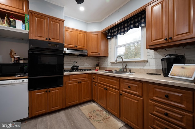 kitchen featuring black appliances, crown molding, sink, light hardwood / wood-style flooring, and backsplash