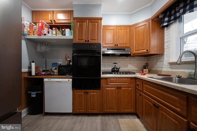 kitchen featuring black appliances, tasteful backsplash, light wood-type flooring, crown molding, and sink