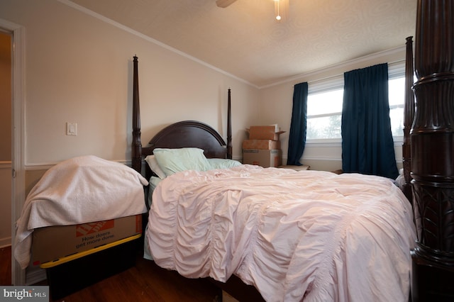 bedroom featuring ceiling fan, ornamental molding, and dark hardwood / wood-style floors