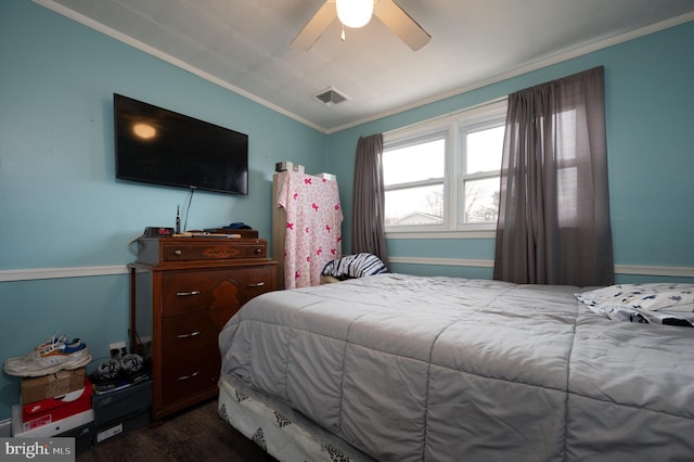 bedroom featuring ceiling fan, ornamental molding, and dark wood-type flooring