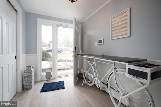 interior space featuring access to outside, light wood-type flooring, and crown molding