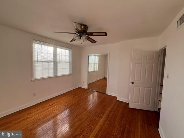 spare room featuring ceiling fan and dark wood-type flooring