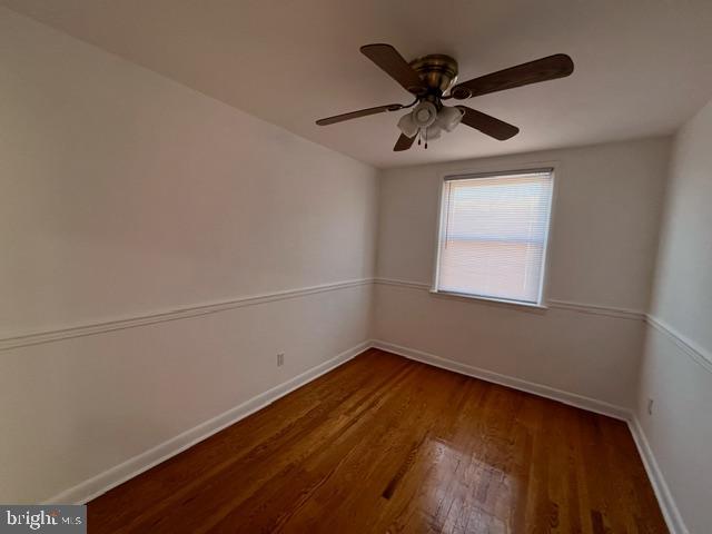 empty room with ceiling fan and dark wood-type flooring