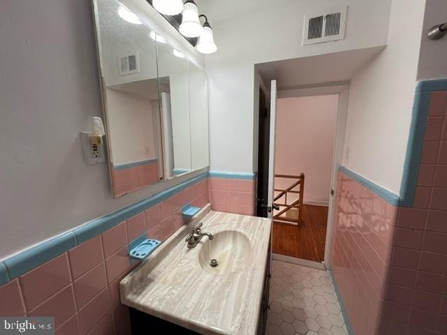 bathroom with vanity, tile patterned floors, and tile walls