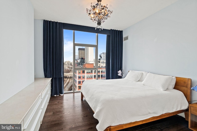 bedroom featuring floor to ceiling windows, dark hardwood / wood-style floors, and a notable chandelier