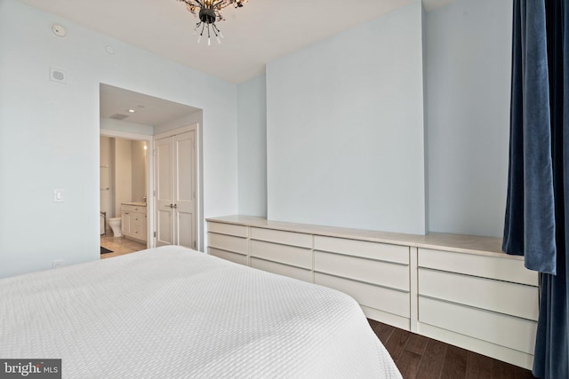 bedroom featuring ensuite bath and hardwood / wood-style flooring