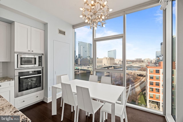 dining space with floor to ceiling windows, dark wood-type flooring, and an inviting chandelier