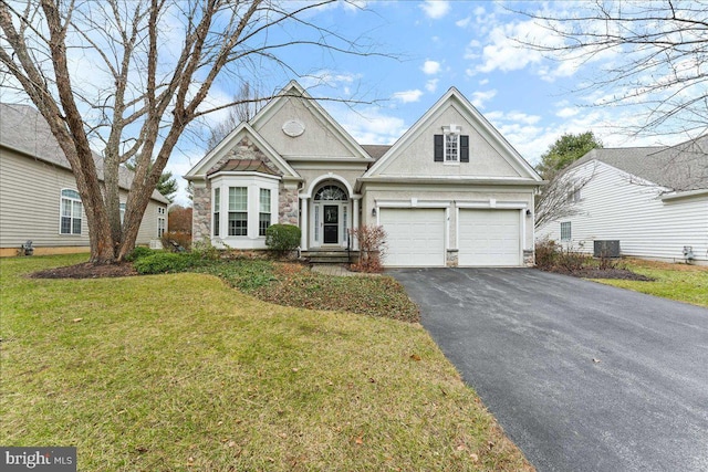 view of front of house featuring cooling unit, a garage, and a front lawn