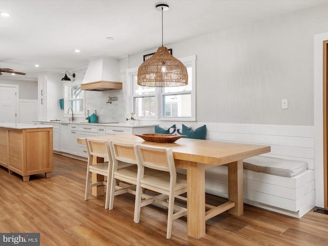 dining space with breakfast area, light hardwood / wood-style flooring, and sink