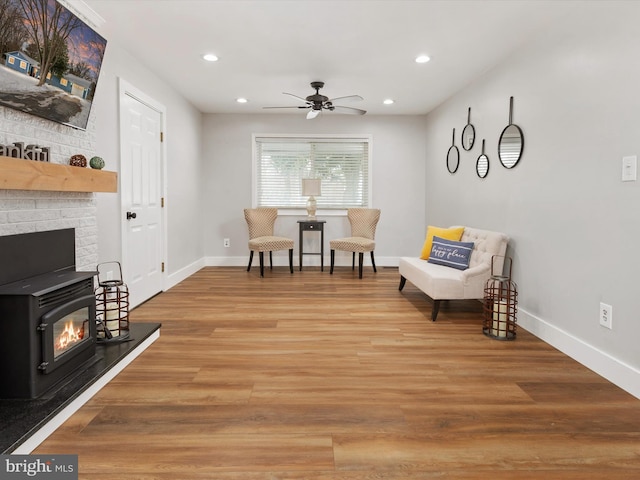 living area featuring hardwood / wood-style floors and ceiling fan