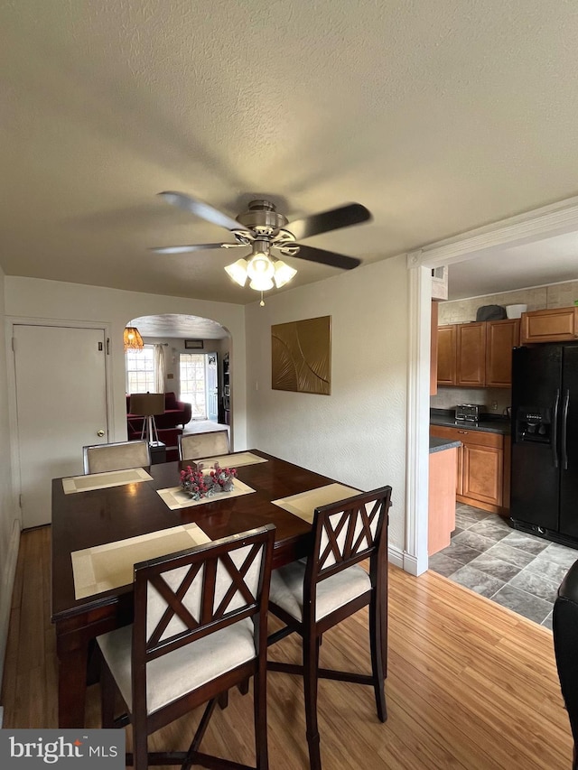 dining space featuring ceiling fan, hardwood / wood-style floors, and a textured ceiling