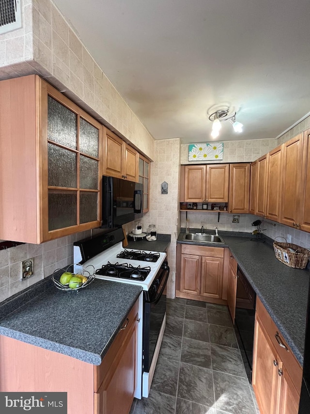 kitchen with tasteful backsplash, sink, and black appliances