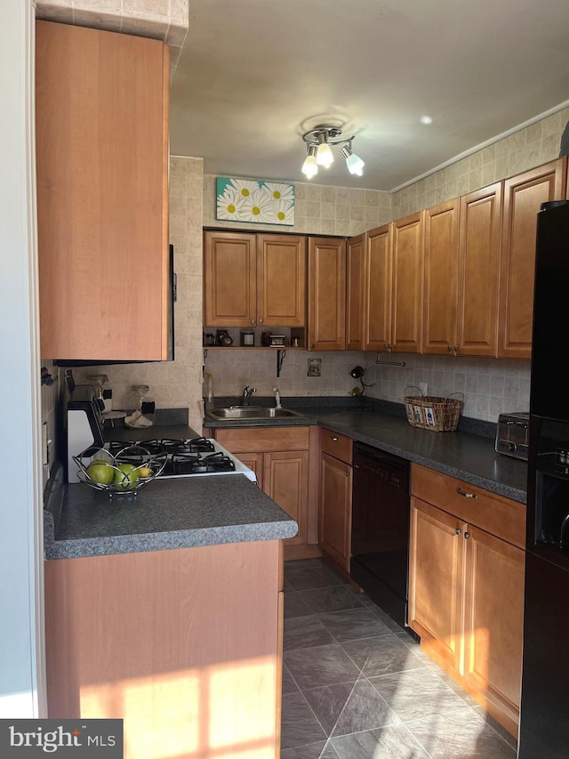 kitchen featuring backsplash, sink, and black appliances