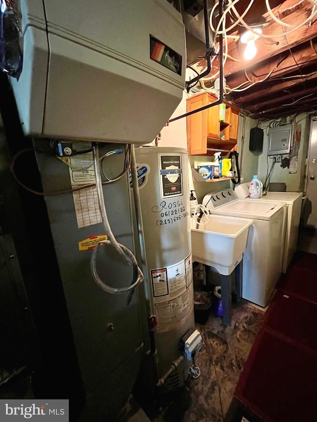 utility room featuring electric panel, water heater, and washer and dryer