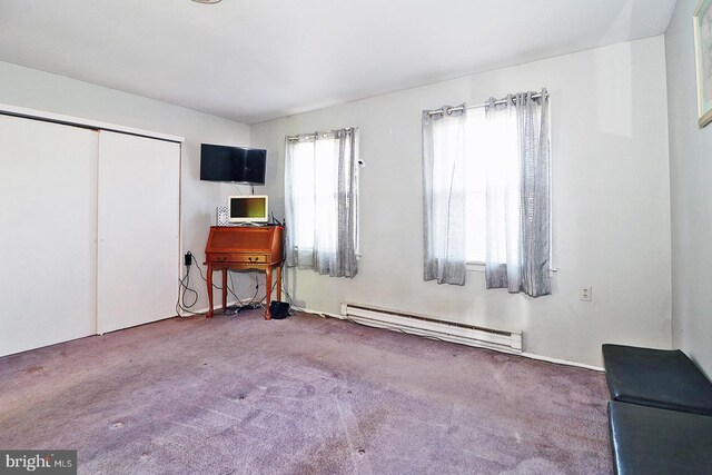 unfurnished bedroom featuring carpet flooring, a closet, and baseboard heating