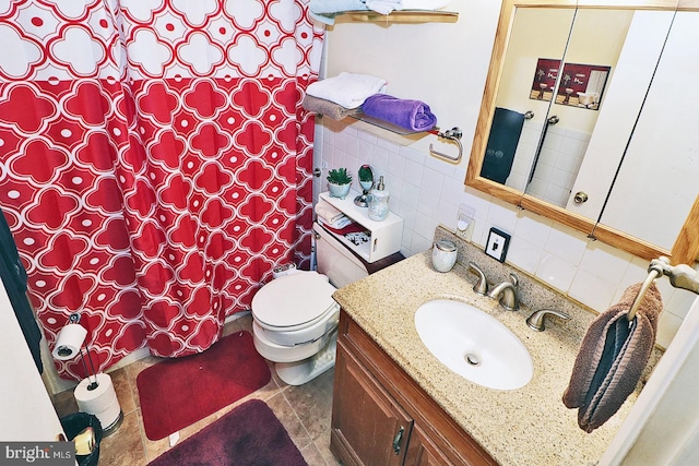 bathroom with tasteful backsplash, tile patterned floors, vanity, tile walls, and toilet