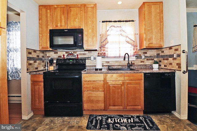 kitchen with black appliances, dark stone countertops, sink, and a baseboard radiator