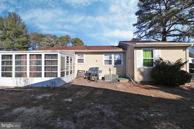 rear view of house featuring central AC and a sunroom