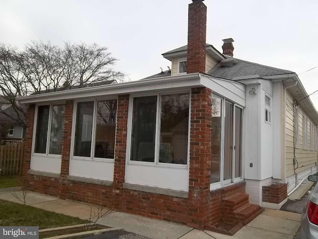 view of home's exterior with a sunroom