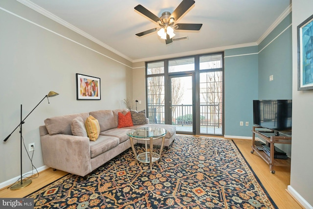 living room with crown molding, ceiling fan, and wood-type flooring