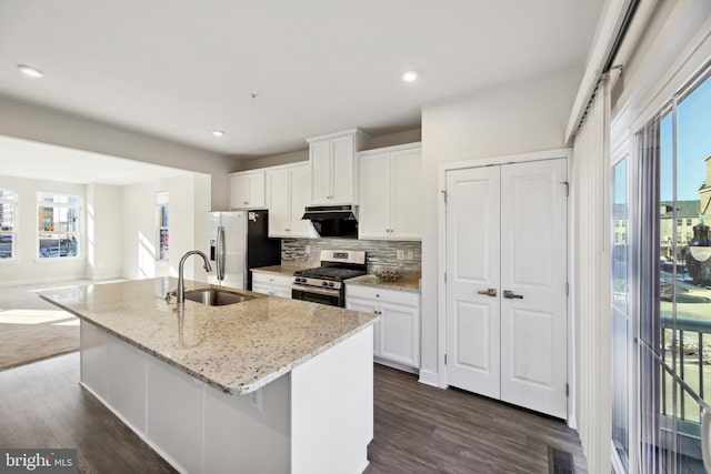 kitchen featuring sink, white cabinetry, appliances with stainless steel finishes, and a center island with sink