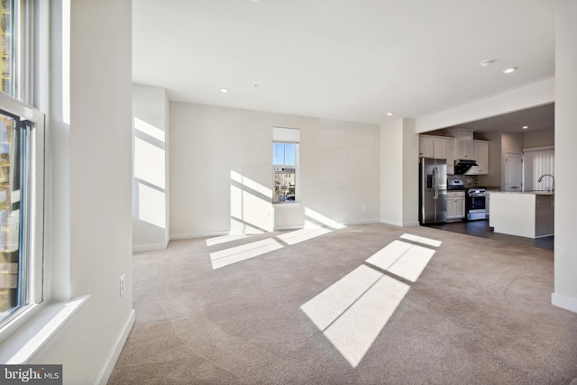 unfurnished living room featuring sink and dark carpet