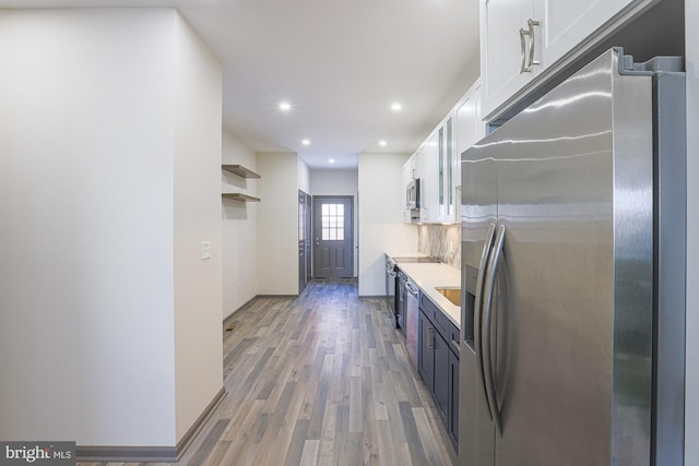 kitchen featuring white cabinets, light hardwood / wood-style floors, and appliances with stainless steel finishes