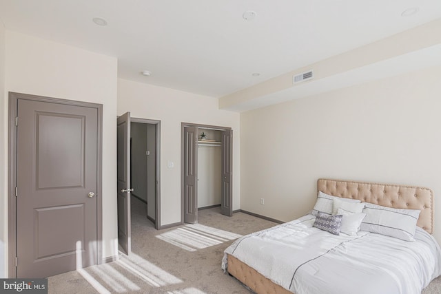 bedroom featuring light carpet and a closet