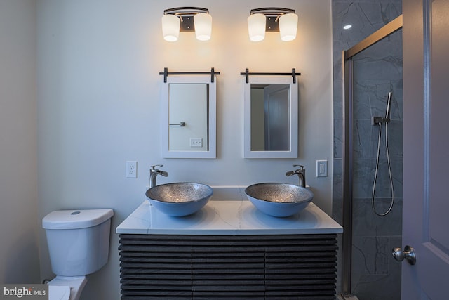 bathroom featuring a tile shower, vanity, and toilet