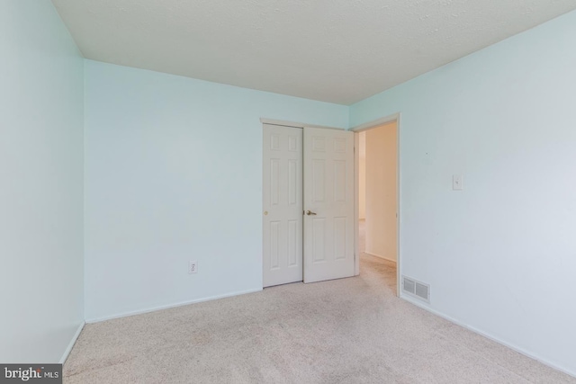 carpeted spare room with a textured ceiling