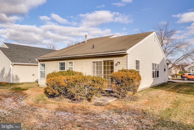 rear view of property with a lawn