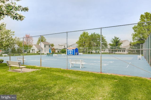 view of sport court featuring a lawn