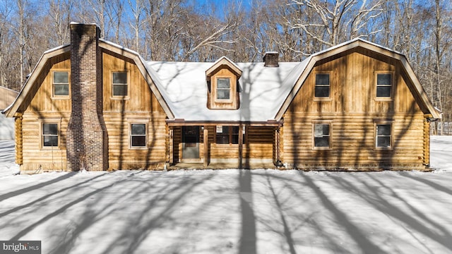 view of snow covered back of property