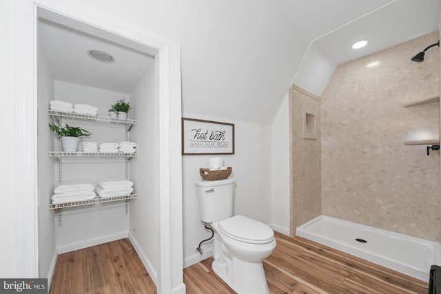 bathroom featuring a shower, wood-type flooring, vaulted ceiling, and toilet