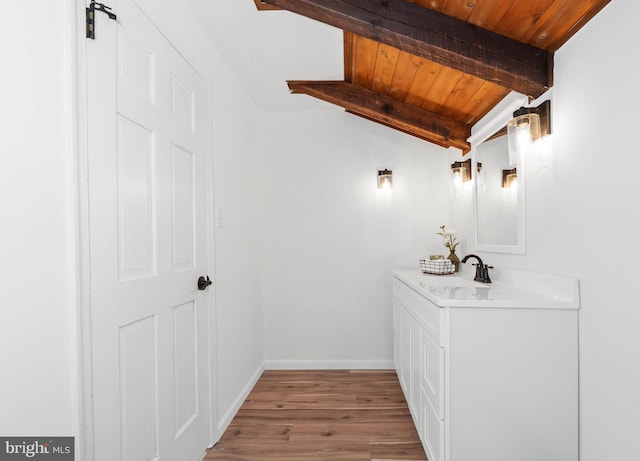 bathroom with vaulted ceiling with beams, vanity, wood ceiling, and hardwood / wood-style flooring