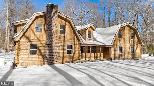 view of snow covered back of property