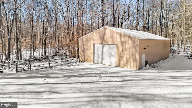 snow covered structure featuring a garage