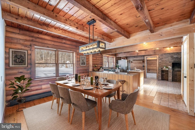 dining room with beam ceiling, wood ceiling, log walls, and light hardwood / wood-style flooring