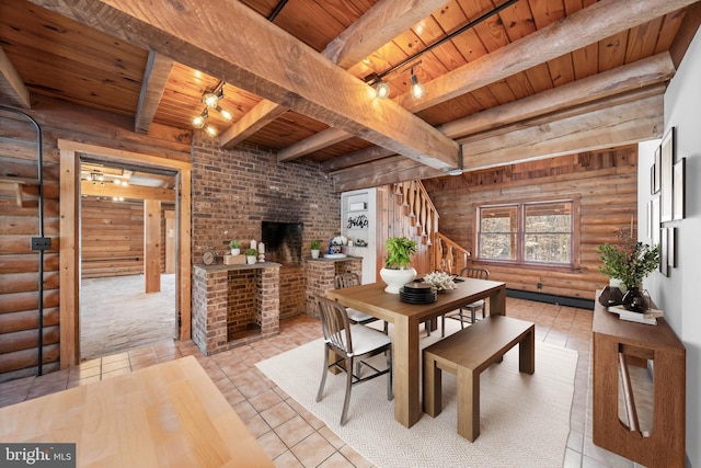 dining room featuring beam ceiling, track lighting, rustic walls, and wooden ceiling