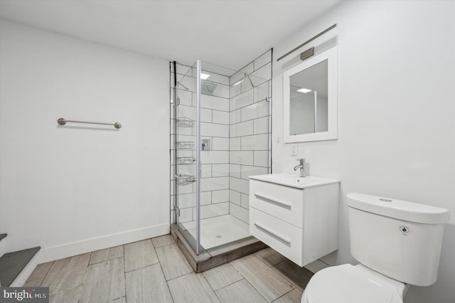 bathroom with vanity, toilet, and a tile shower