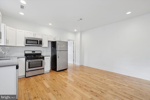 kitchen with white cabinetry, sink, light hardwood / wood-style flooring, and appliances with stainless steel finishes