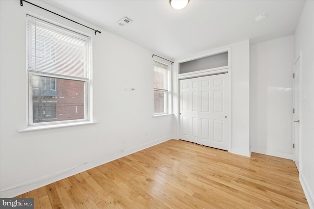 unfurnished bedroom with light hardwood / wood-style floors and a closet