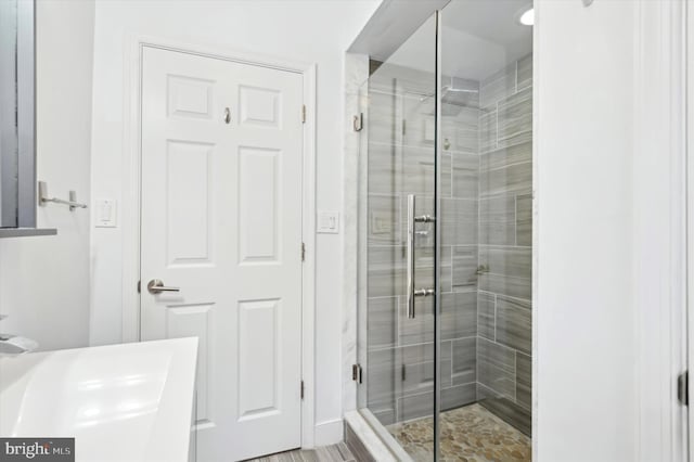 bathroom with an enclosed shower and sink