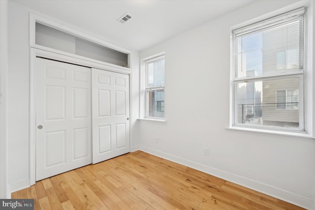 unfurnished bedroom with a closet and light wood-type flooring