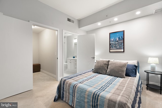 bedroom with light colored carpet and ensuite bathroom