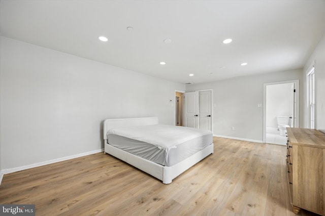 bedroom featuring light wood-type flooring and connected bathroom