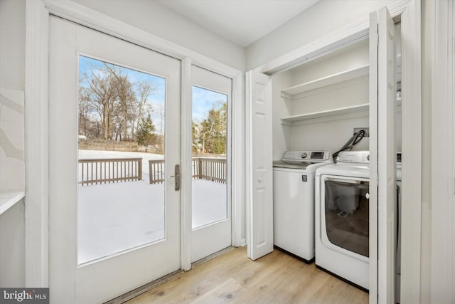 laundry room featuring light wood-type flooring and washing machine and clothes dryer