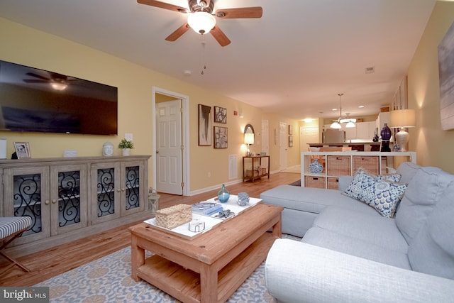 living room with ceiling fan and light hardwood / wood-style floors